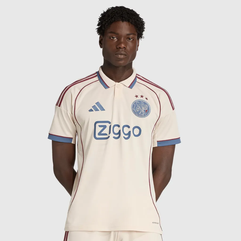 Camisa terceira Ajax 2025 2026 adidas bege Halo Ivory com detalhes azul e vermelho escuro e referências históricas a Amsterdã 1275