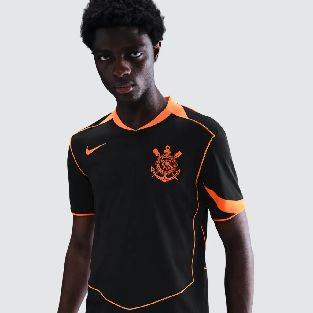 Camisa terceira do Corinthians Nike 2025 2026 preta com detalhes laranja, círculo Total 90 no peito, escudo do Corinthians em destaque e design inspirado na era T90