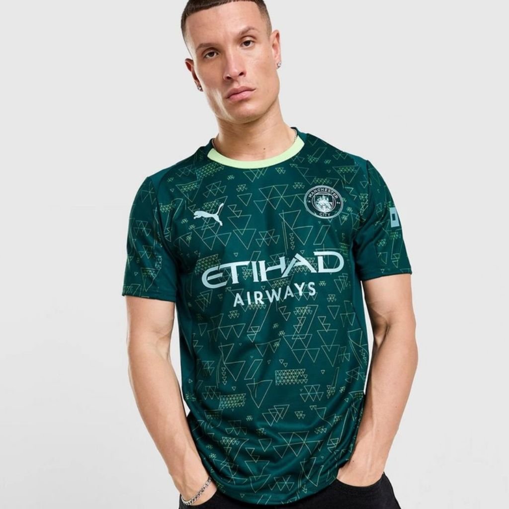 Quarta camisa Manchester City PUMA 2025-2026 verde escura com chip NFC e escudo metálico do EA SPORTS FC.