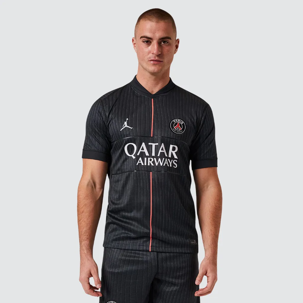 Quarta camisa do Paris Saint-Germain Jordan 2025/26 em tom Off Noir, com detalhes em rosa pérola, logo Jordan rosa claro e design minimalista inspirado na moda parisiense.