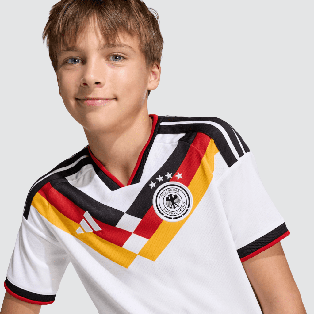 Conjunto infantil Alemanha titular2026 adidas branco e preto com detalhes da bandeira e escudo bordado.